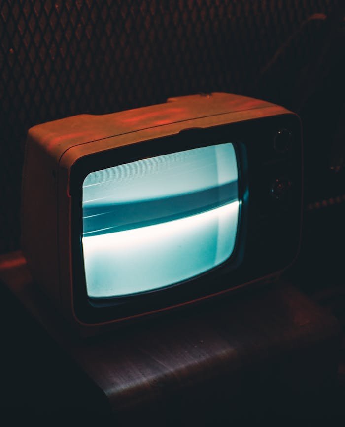 services-03 A vintage television glowing in a dark, retro ambiance.
