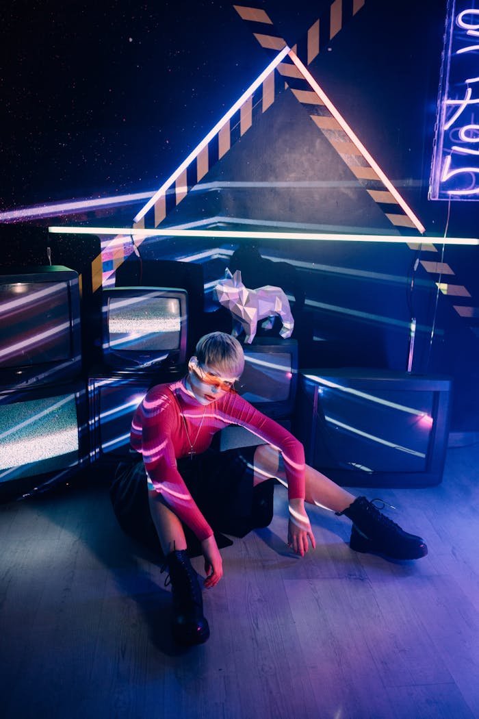 who-we-are A person in vibrant neon lighting with a geometric and retro-futuristic backdrop.