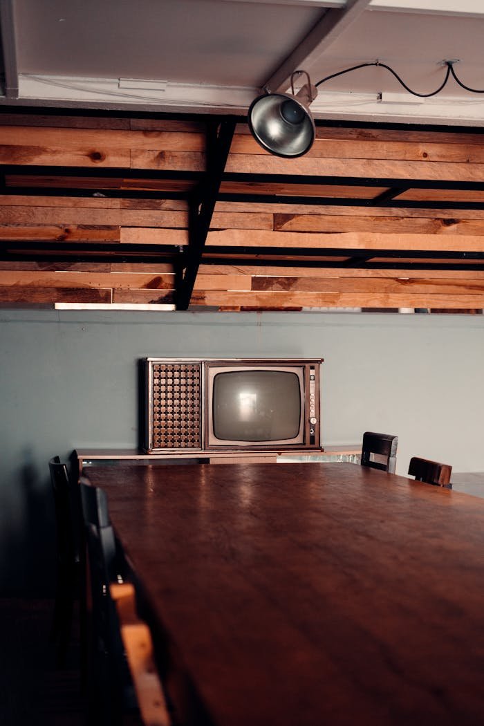 team-02 A nostalgic scene featuring a vintage TV on a wooden table within a rustic room in CDMX, Mexico.